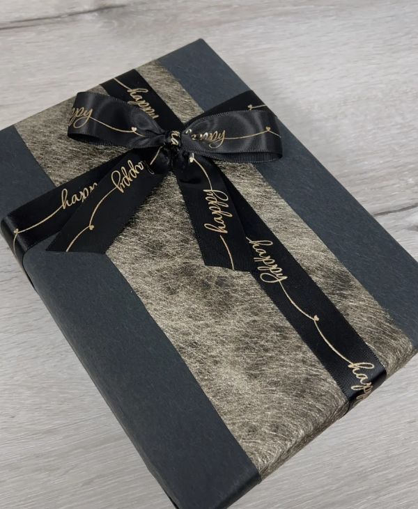 Close-up of a pencil pet portrait being wrapped in tissue paper inside its presentation box.